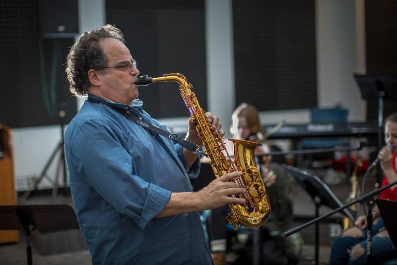 Jeff playing sax in front of some students